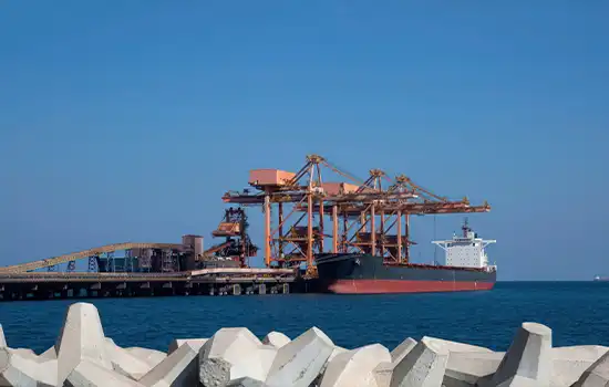 An image of the quay and facilities at Sohar Port, Oman, featuring a docked cargo ship.