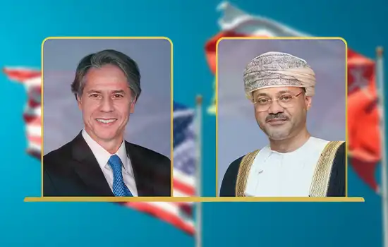 صورة لوزير الخارجية العُماني بدر بن حمد البوسعيدي ووزير الخارجية الأمريكي أنتوني بلينكن مع أعلام البلدين في الخلفية.