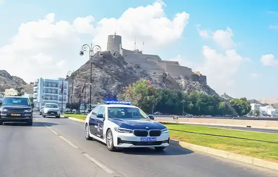 Five Arrested for Stealing Money from a Bank Customer in Muscat 7 An image of an Omani police car patrolling the streets of Muscat with the historic Muttrah Fort in the background.