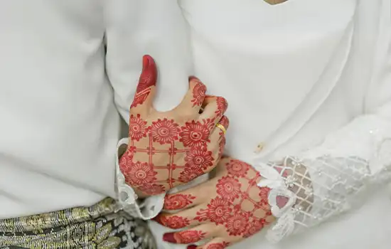 An image of a bride's hands adorned with henna, symbolizing marriage and its cultural significance in Oman.