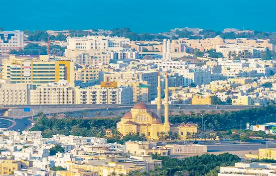 A panoramic view of Muscat, Oman, featuring residential and commercial buildings, symbolizing the growth of real estate in the country.