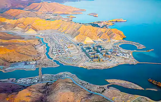 An aerial view of a large real estate development project in Oman, showcasing the rapid growth of the country's property market.