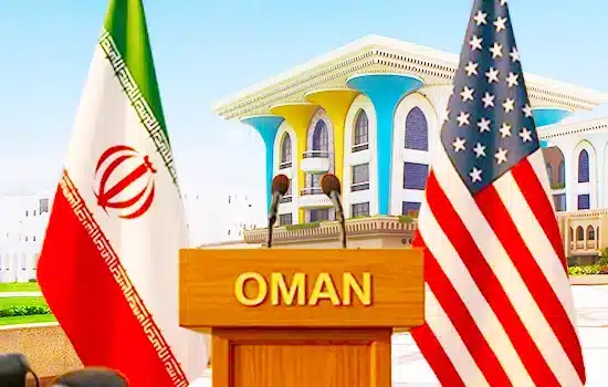 Omani podium with Iranian and U.S. flags in front of a government building in Muscat