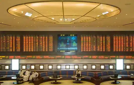 Image of the Muscat Stock Exchange trading hall, displaying market value and ongoing stock transactions.