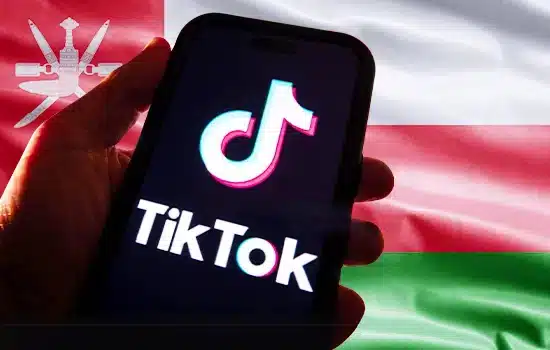 إتاحة تطبيق "تيك توك" في سلطنة عُمان دون الحاجة إلى VPN 1 شعار تطبيق TikTok على شاشة هاتف محمول وخلفه علم سلطنة عمان
